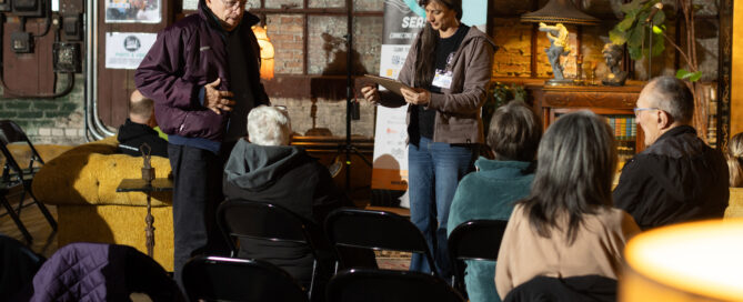 Megan McGee and an older man stand next to each other on the stage at the Dandy.